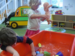 Using water to wash the babies in the sensory tub!